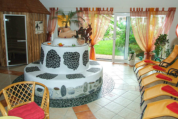Wellness area with tiled stove and lounge chairs
